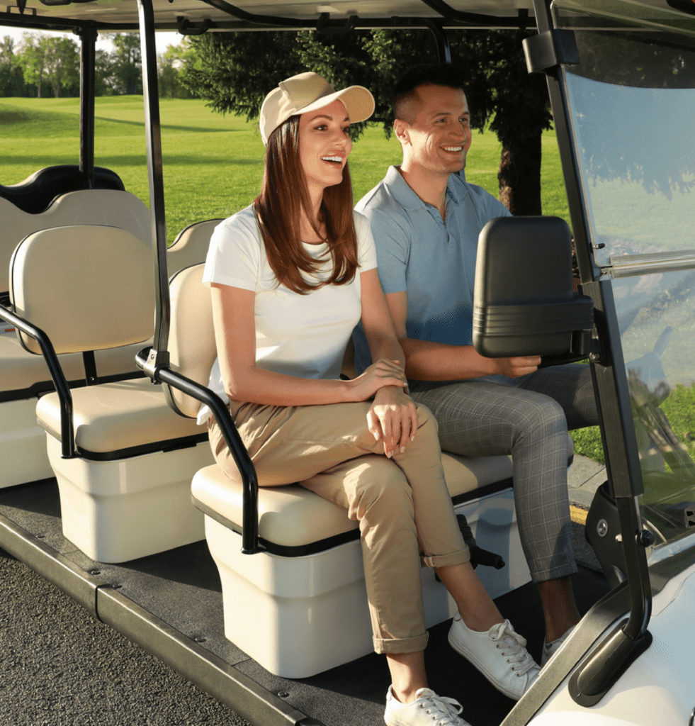 Happy Couple Driving Golf Cart on Road in Park